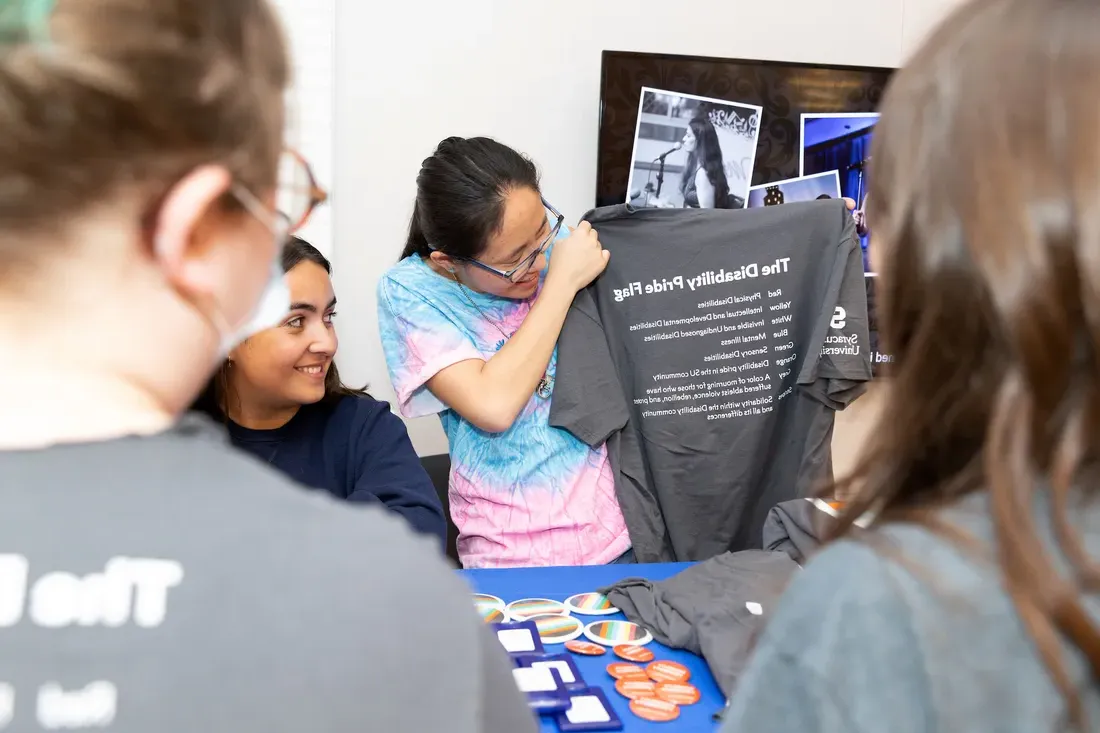 Student holding a T-shirt.